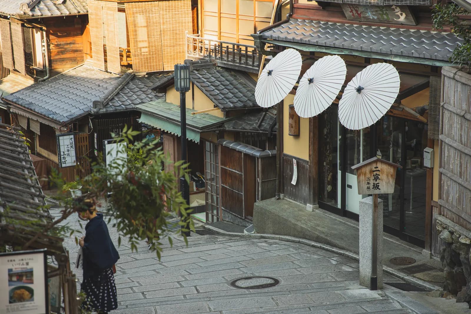 Traveler seen from above on a sunlit historic Kyoto street